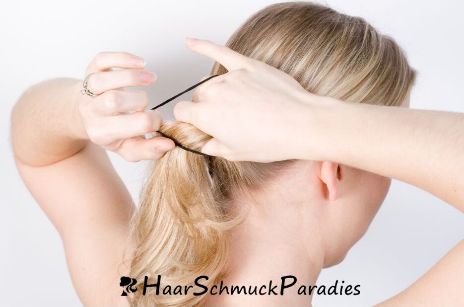 Mädchen bindet einen tiefen Pferdeschwanz